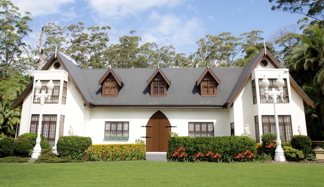 Scottish Manor nestled in lush tropical Rainforest next to bubbling stream.